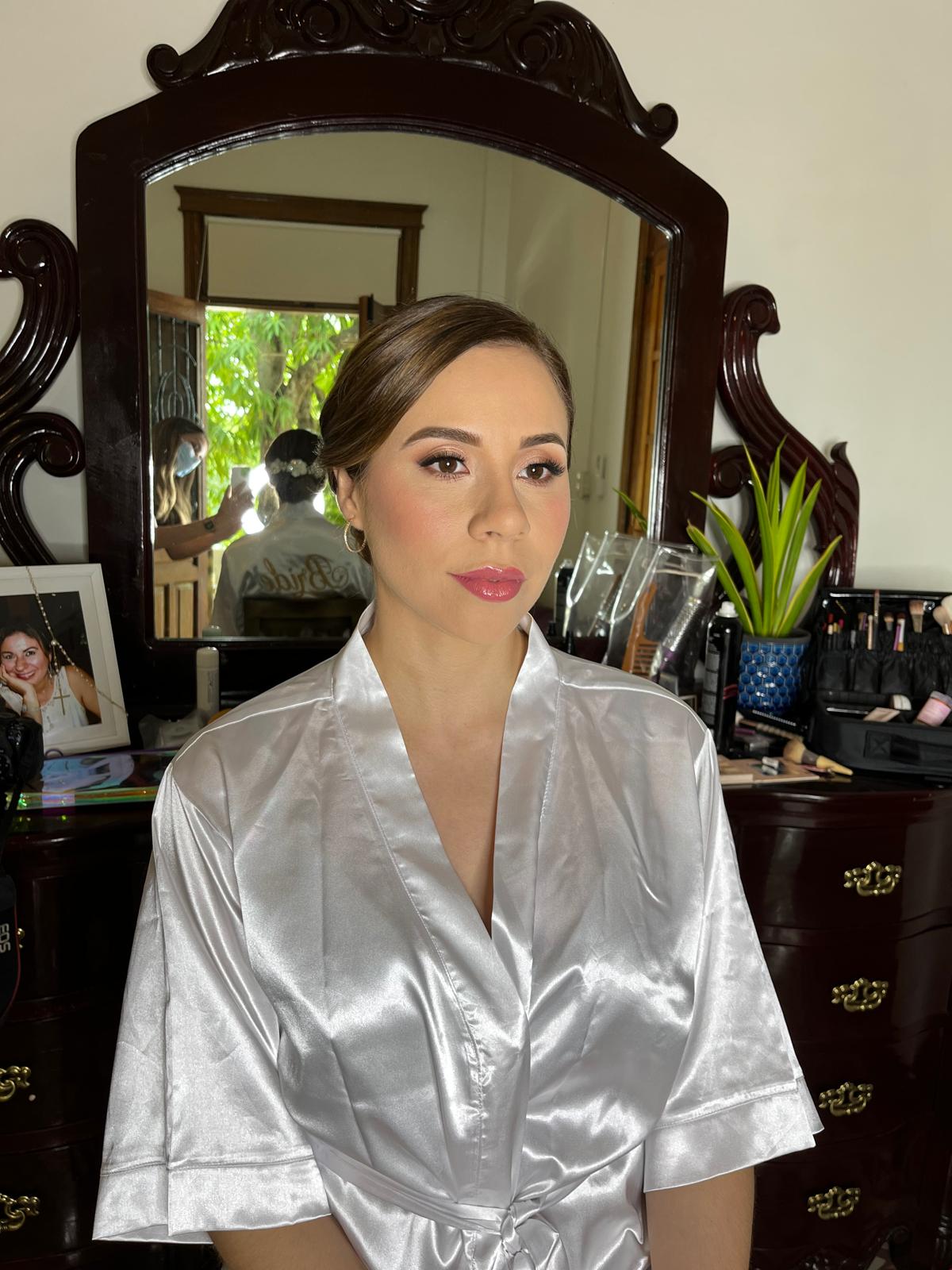 Novia con bata de satén frente al tocador