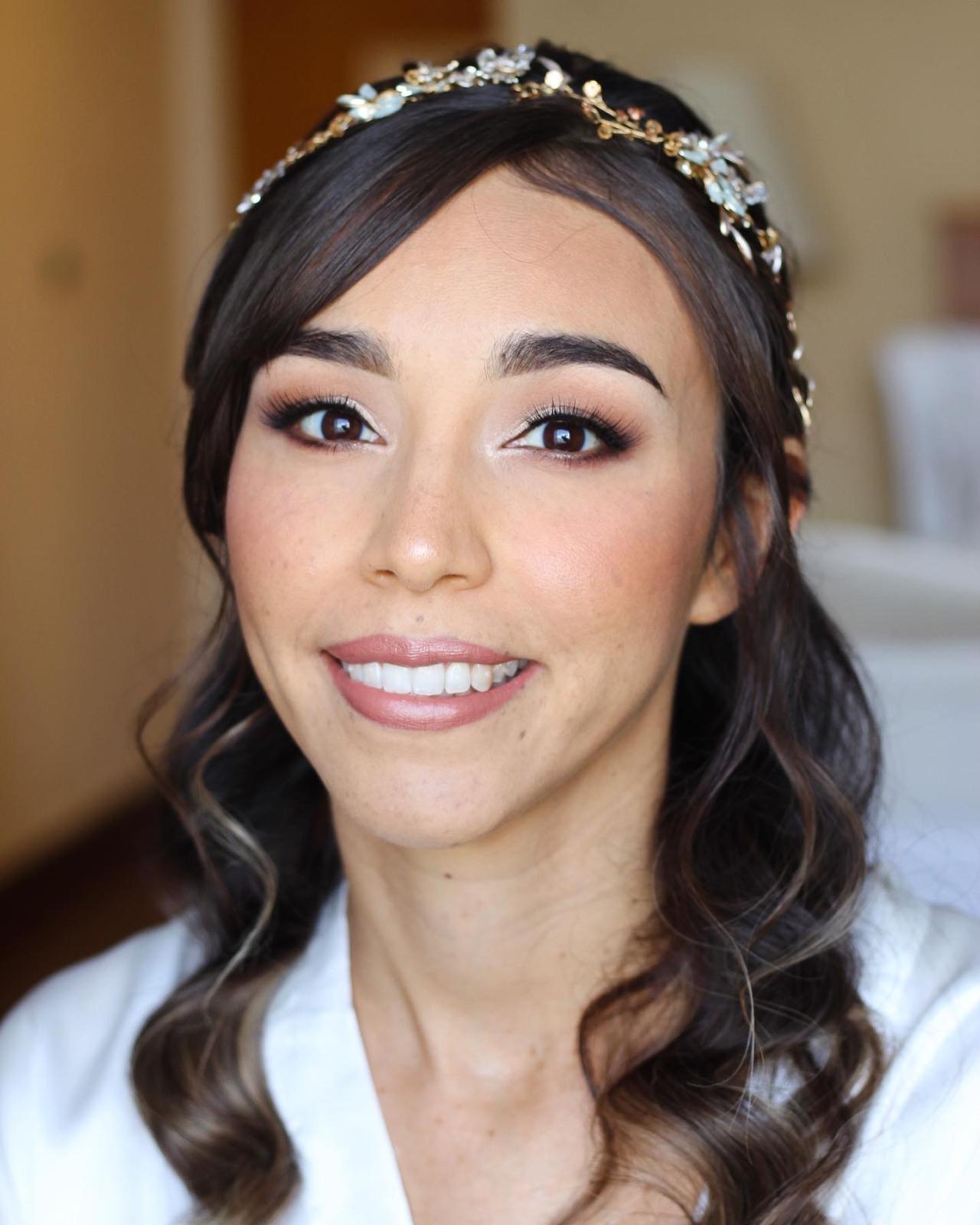 Novia sonriente con tocado dorado y labios rosados